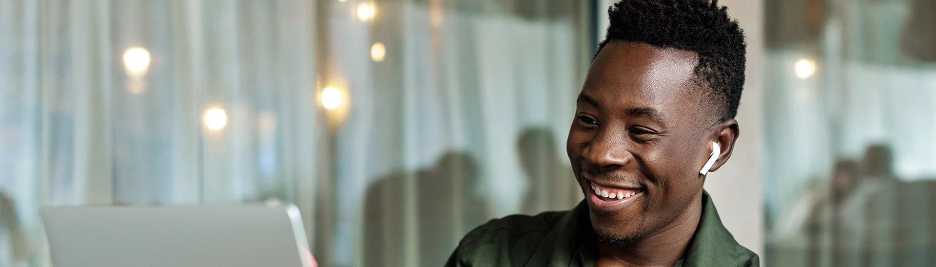 Smiling African American Man looking at laptop with headphones in