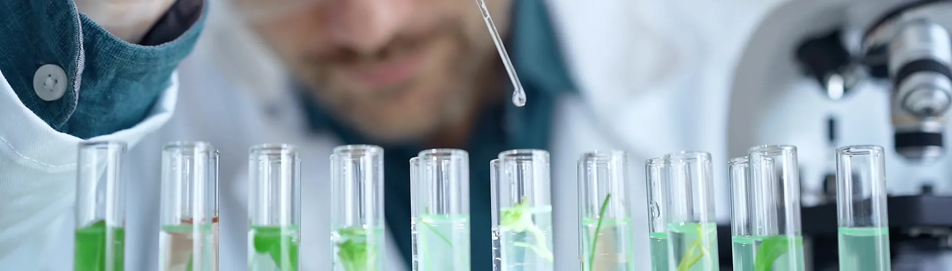 A chemist working to precisely measure liquid going into different vials for quality management.