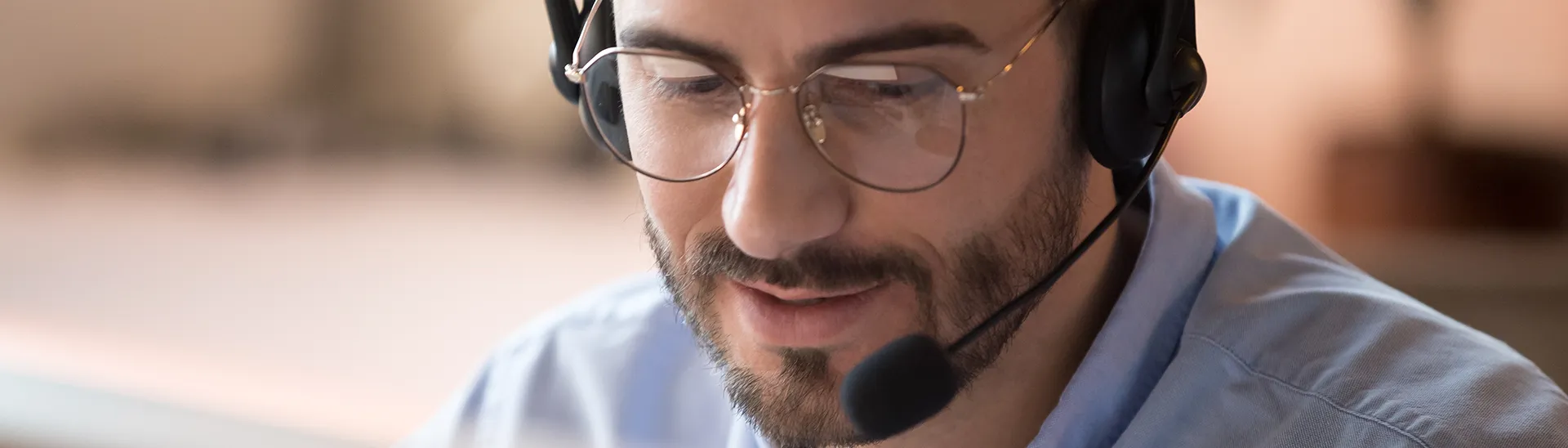 Un hombre con auriculares atiende a una persona que llama por teléfono.