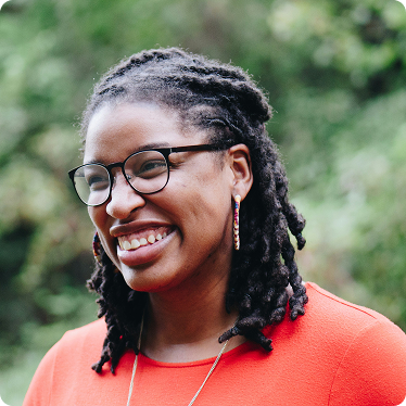 Black woman smiling in orange shirt