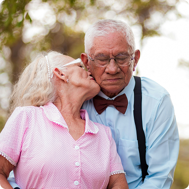 Pareja de ancianos. La mujer besa la mejilla del marido